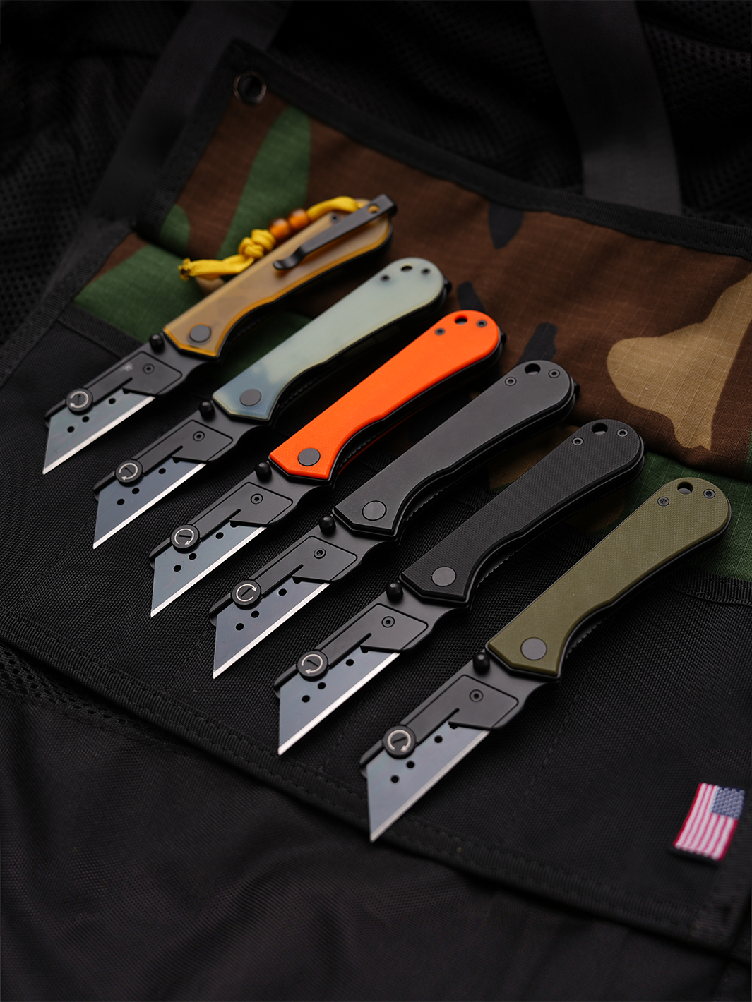 U23 Gen 2 black blade folding utility knives displayed in an outdoor EDC setting with multiple handle finishes